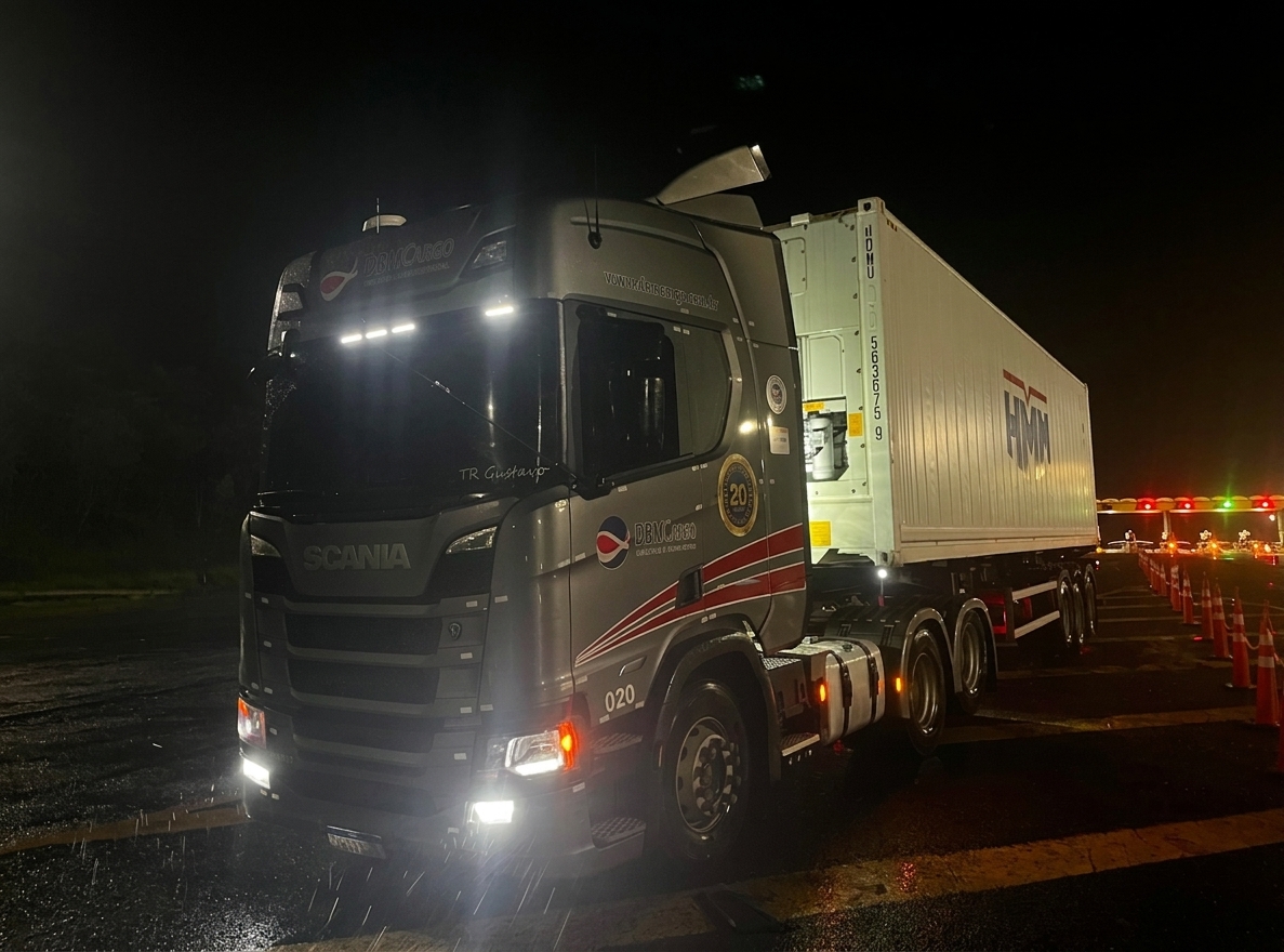 Caminhão Scania DBM Cargo com contêiner HMM em operação noturna